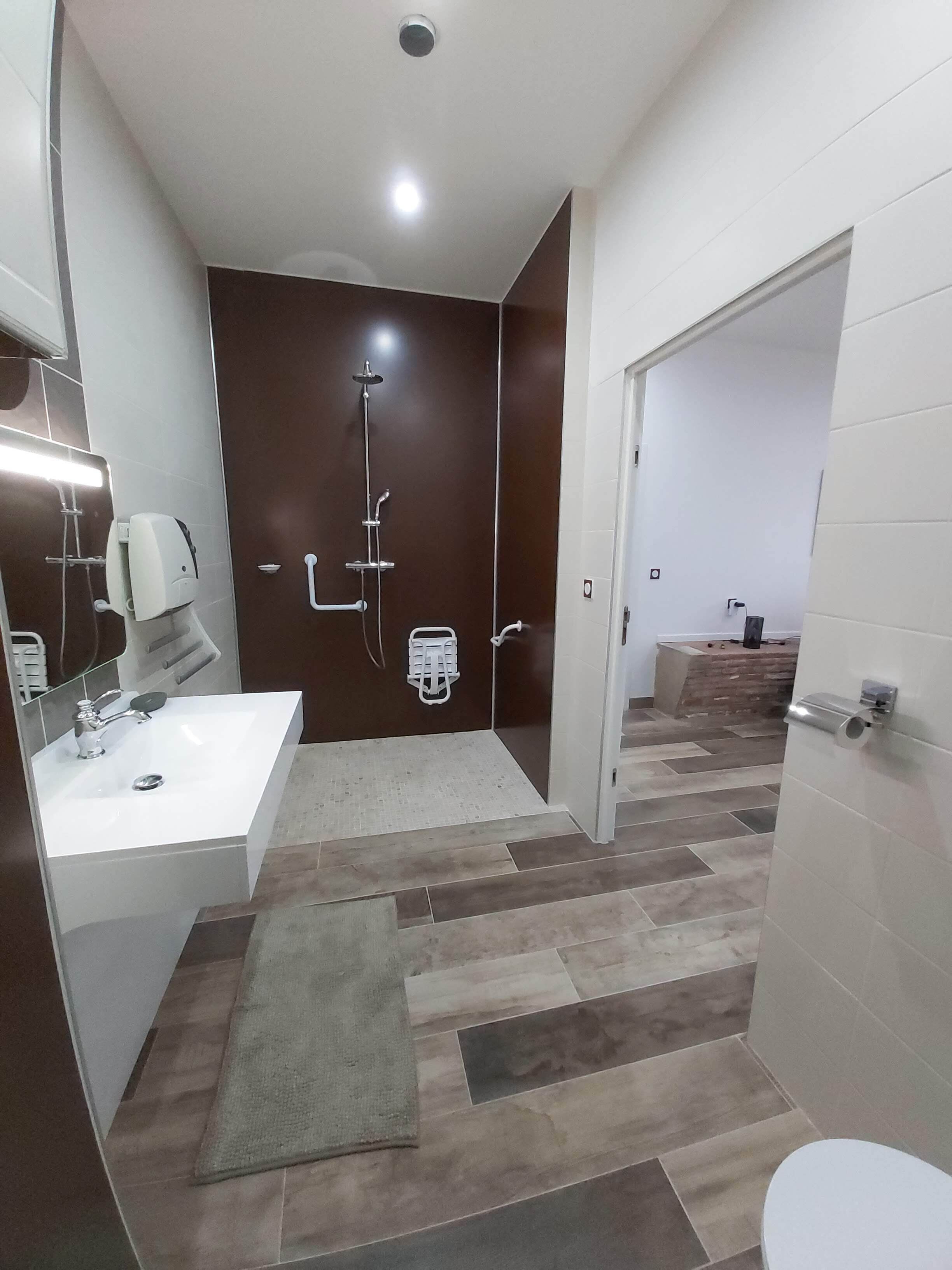 A modern bathroom with a shower, sink, and toilet.