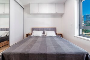 A bedroom with a large bed, a wardrobe, and a window with a view. - Casa Laurea (Dubrovnik)