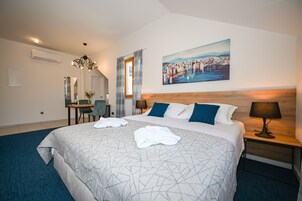 Habitación de hotel con una cama grande, un escritorio, una silla y un cuadro en la pared.