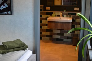 A modern bathroom with a sink, mirror, and tiled backsplash. - A stylish vacation loft in the Emsland region that sleeps 6, featuring a sauna and an outdoor pool (Emsbüren)