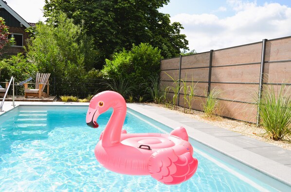 A swimming pool with a pink flamingo float. - A stylish vacation loft in the Emsland region that sleeps 6, featuring a sauna and an outdoor pool (Emsbüren)