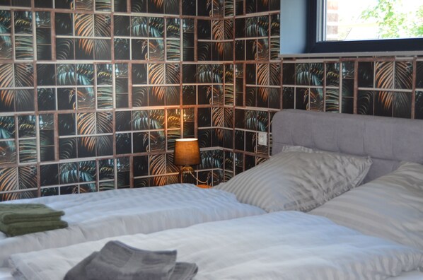A bedroom with a bed, pillows, a lamp, and a window. - A stylish vacation loft in the Emsland region that sleeps 6, featuring a sauna and an outdoor pool (Emsbüren)