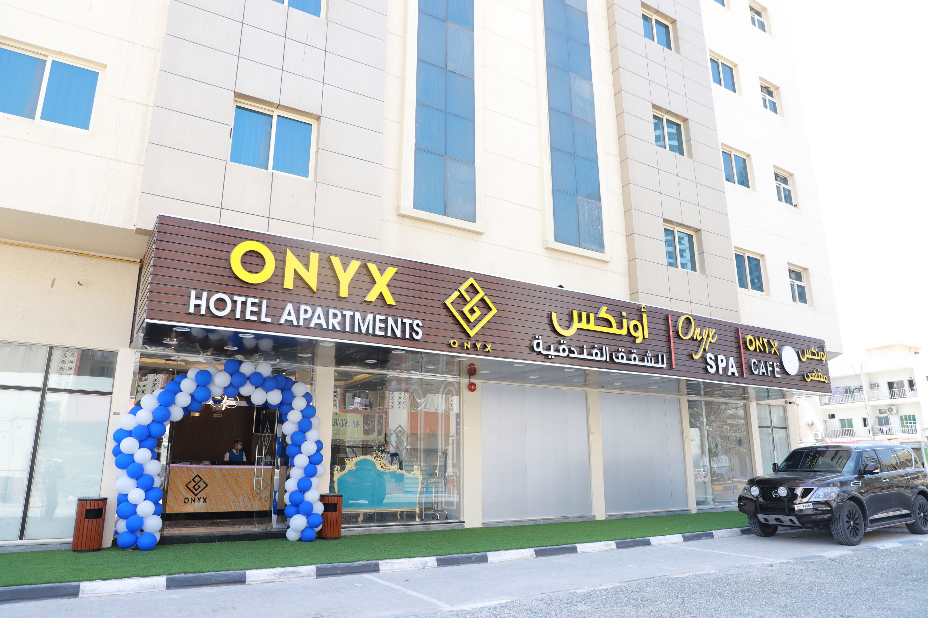 Un hôtel avec une enseigne indiquant « ONYX HOTEL APARTMENTS » et « ONYX SPA CAFE ».