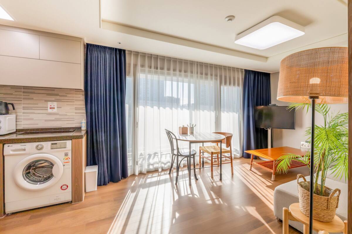 Ein modernes Hotelzimmer mit Küche, Essbereich und Wohnbereich.