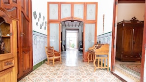 A room with a patterned floor, wooden furniture, and a decorative archway.