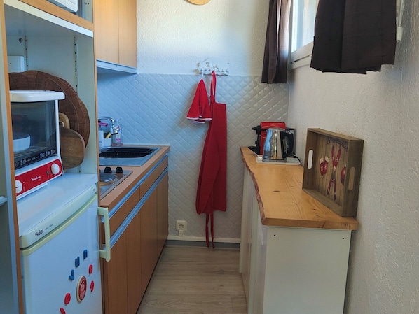A compact kitchen with a stove, sink, and a small countertop.