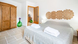 Un dormitorio con cama, armario, espejo y decoración en la pared.