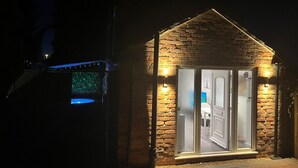 A brick building with a triangular roof and a glass door entrance. - Jacuzzi Spa! Stunning Entire Guest House - Netflix (Derby)