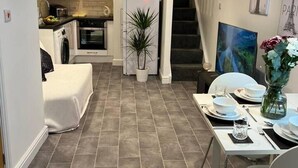 A compact living space with a kitchen, dining area, and a staircase leading to an upper level. - Jacuzzi Spa! Stunning Entire Guest House - Netflix (Derby)