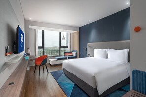 A modern hotel room with a large bed, a seating area with a view, a flat-screen TV, and a wooden floor. - Holiday Inn Express Lanzhou New District by IHG (Lanzhou)