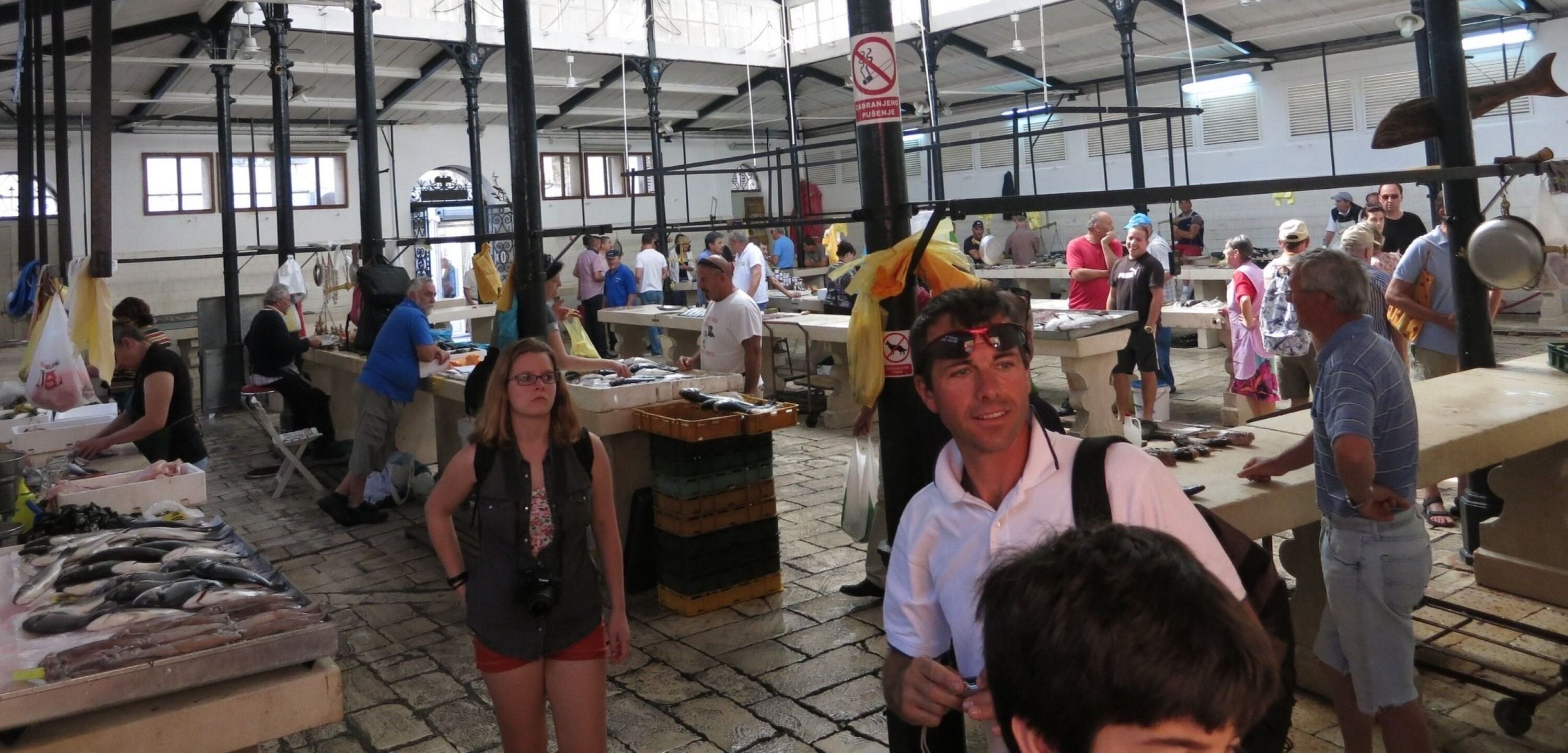 An indoor market with various stalls and people browsing.