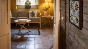 A room with a sofa, a small table, a lamp, and a window with shutters. - Villa "Masia Can Comas" with Pool, Garden & Wi-Fi (Torrelavit)