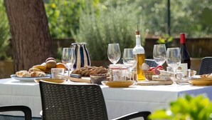 An outdoor dining table with food, drinks, and glassware. - Villa "Masia Can Comas" with Pool, Garden & Wi-Fi (Torrelavit)
