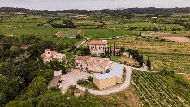 A large estate with multiple buildings, expansive green fields, and a mountainous backdrop. - Villa "Masia Can Comas" with Pool, Garden & Wi-Fi (Torrelavit)