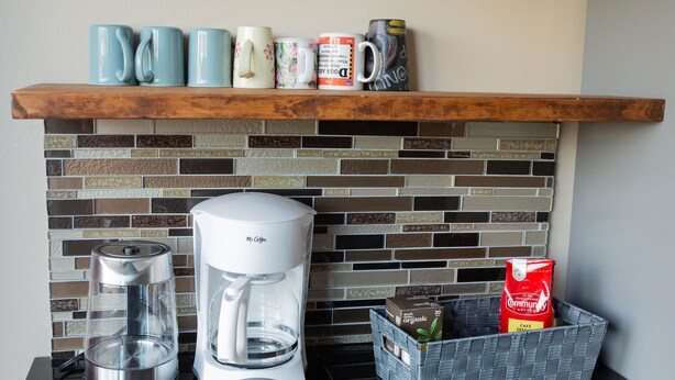 Eine Küche mit Kaffeemaschine, Wasserkocher und einer Korb mit Kaffeebohnen und Kaffeefilter.