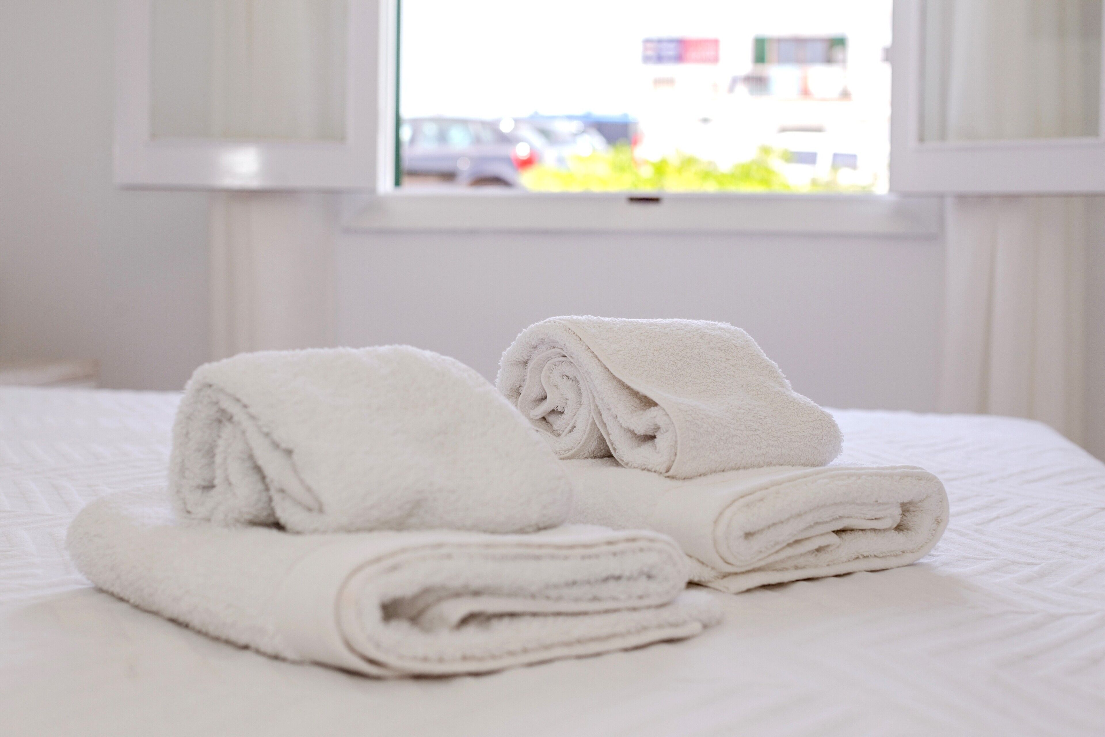 A neatly made bed with folded white towels.