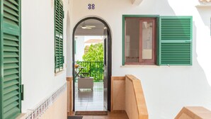 A hallway with a tiled floor, a door leading to a balcony, and a number '38' above the door. - Apartment "Los Delfines Biniforcat" with Private Covered Terrace and Shared Pool (Ciudadela)