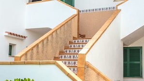 A staircase with patterned tiles and a white wall. - Apartment "Los Delfines Biniforcat" with Private Covered Terrace and Shared Pool (Ciudadela)