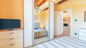 Una camera da letto con un letto, una TV e un comò.