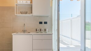 Une cuisine moderne équipée d’un évier, de placards et offrant une vue sur l’extérieur.
