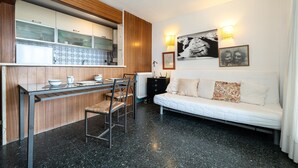 A compact living space with a kitchenette, a dining area, and a sofa.