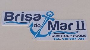 Un letrero de hotel con el nombre 'Brisa do Mar II' e información de contacto.
