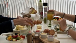 A dining table set with croissants, fruit, condiments, and a bottle of olive oil. - Hotel Tayko Sevilla (Seville)