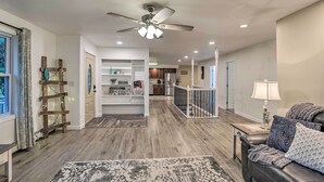 A spacious living area with a ceiling fan, a fireplace, and a view of the kitchen and dining area. - Cozy Seneca Falls Home Close to Cayuga Wine Trail! (Seneca Falls)