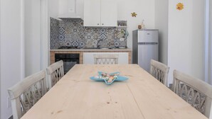 Ein Essbereich mit einem Holztisch, Stühlen und einem blauen Deko-Arrangement.