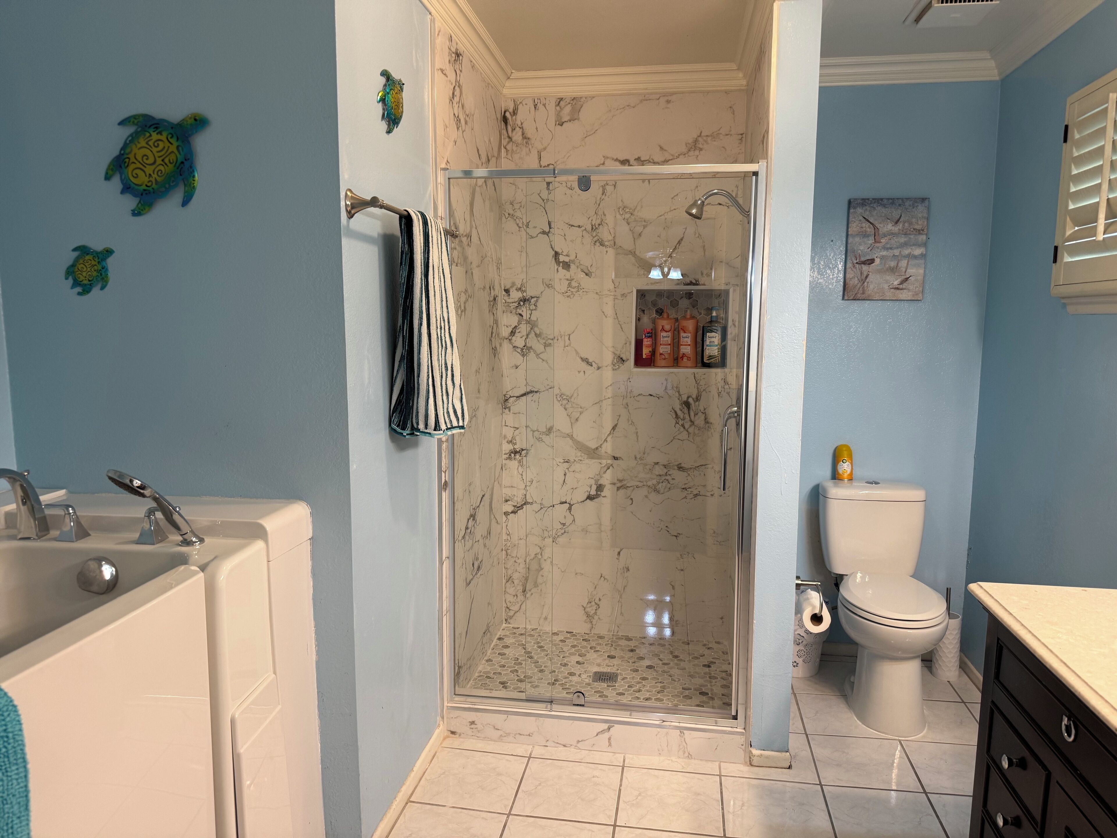 Ein Badezimmer mit Duschkabine, Badewanne, Toilette und Waschbecken.