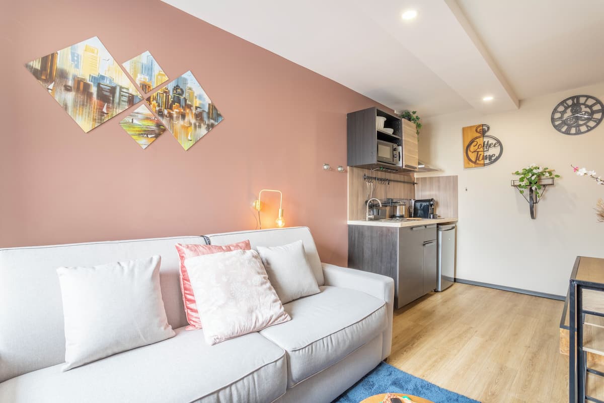 Una sala de estar moderna con un sofá, una mesita de centro y una cocina al fondo.