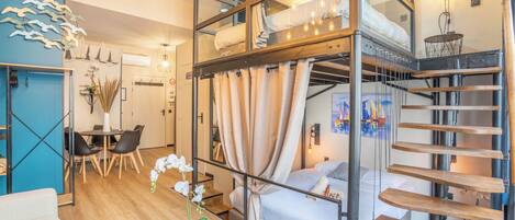 Een modern interieur met een stapelbed, een eethoek en een trap.
