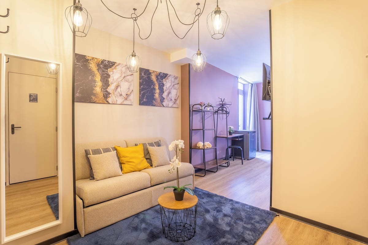 Una sala de estar moderna con un sofá, una mesa de centro y una planta en maceta.