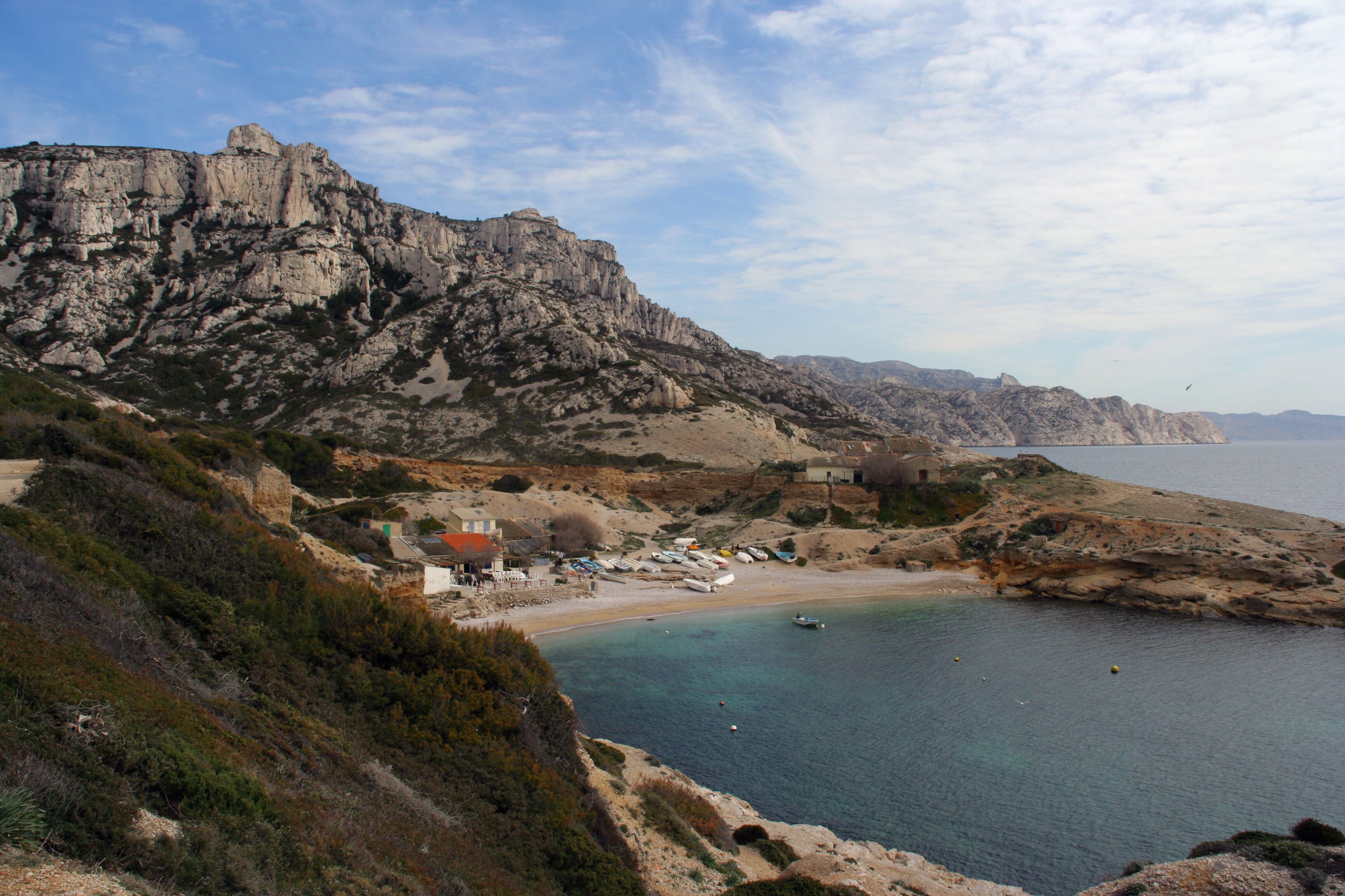 Un paysage côtier caractérisé par des falaises rocheuses, une plage et un petit village.