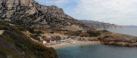 Un paysage côtier caractérisé par des falaises rocheuses, une plage et un petit village.