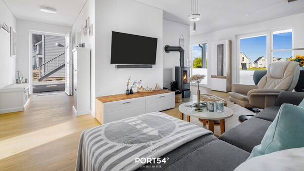 A modern living room with a sofa, a coffee table, a TV, and a fireplace. - Leicht Matrose - Fireplace, Terrace, Infrared Sauna, Shower, Washing Machine (Olpenitz)