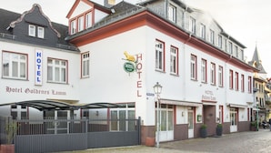 Hotel Goldenes Lamm with a prominent sign, a covered entrance, and a cobblestone street. - Hotel Goldenes Lamm (Idstein)
