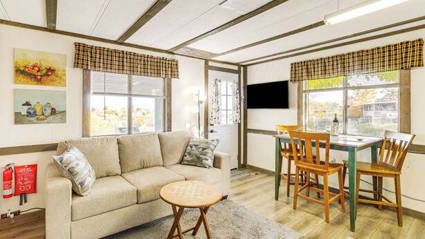 A cozy living room with a sofa, round coffee table, wooden chairs, and a TV. - 6 Mi to Old Town, Panoramic Views: Cottonwood Gem! (Cottonwood)