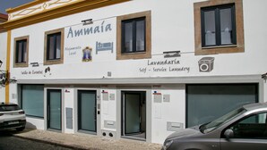 A building with a sign reading "Ammaia Alojamento Local" and "Lavanderia Self-Service Laundry".