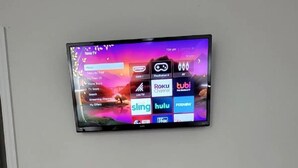 A flat-screen TV mounted on a wall displaying a TV guide interface with various streaming services. - #9 Hideaway (Tampa)