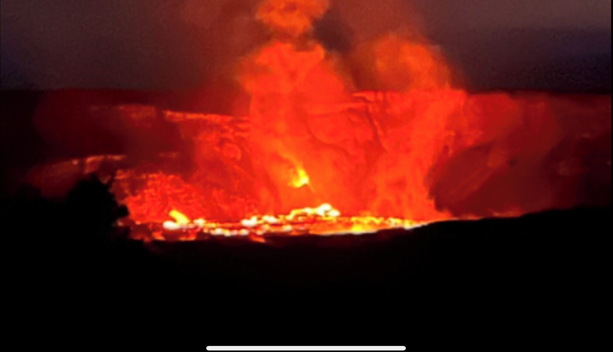 A lava flow with glowing red and orange hues, indicating active volcanic activity.