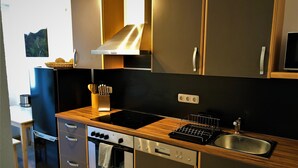 A modern kitchen with wooden countertops, a built-in oven, a dishwasher, and a stainless steel sink. - Modern furnishings.  "Wanderfalke" Vacation Rental, Central & Quiet, 55 sqm, Shared Terrace (Königstein)