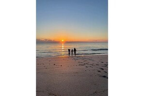 Guests can enjoy a serene beach experience with calm waves lapping at the shore.