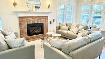 TV connectée, cheminée, livres, écrans d'ordinateur