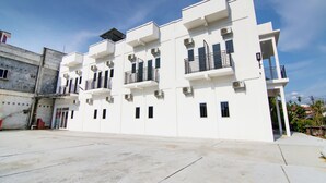 Un edificio de varios pisos con balcones y unidades de aire acondicionado.