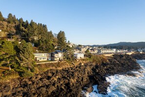 A coastal town with houses on a cliff overlooking the ocean.