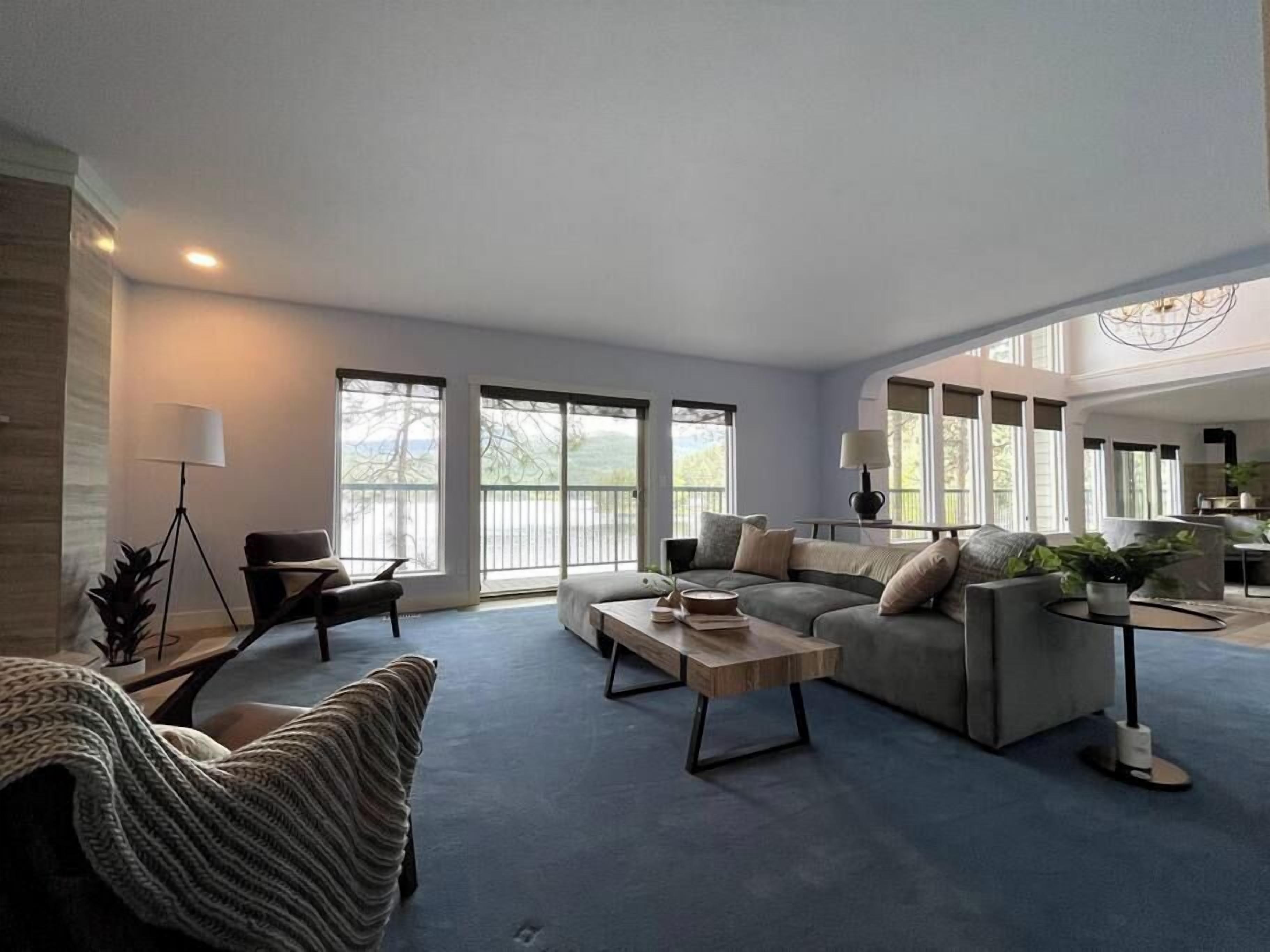 A spacious living room with a large sofa, a coffee table, and a dining area.