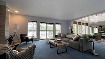 A spacious living room with a large sofa, a coffee table, and a dining area.