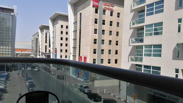 A modern building with a sign for ibis hotels. - AlBarsha 1 Hostel By PHM (Dubai)