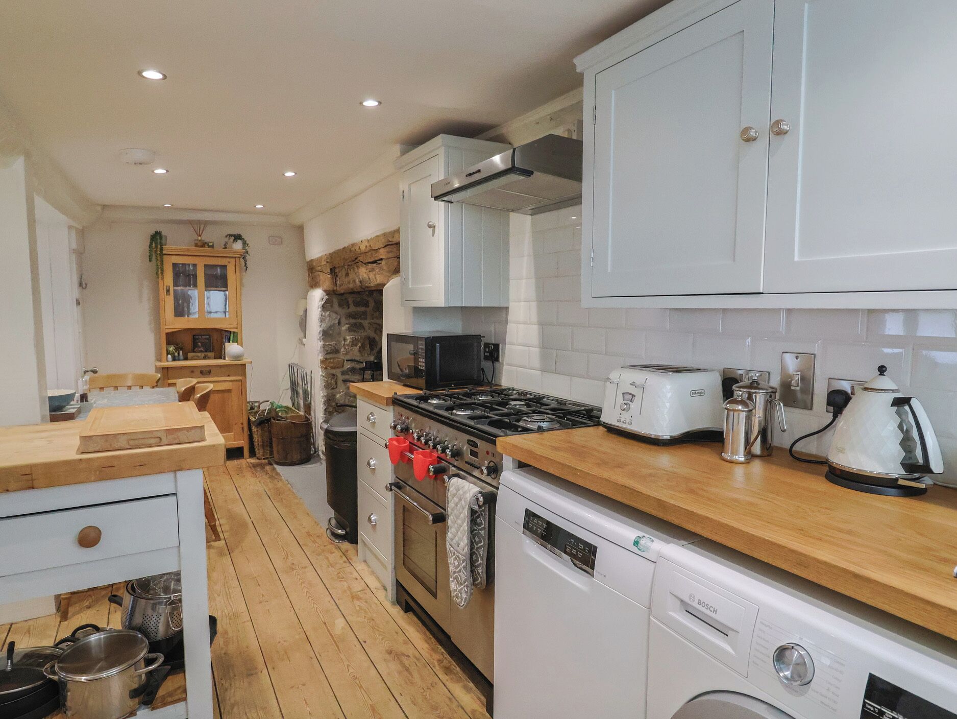 A kitchen with a stove, oven, microwave, toaster, and dishwasher.